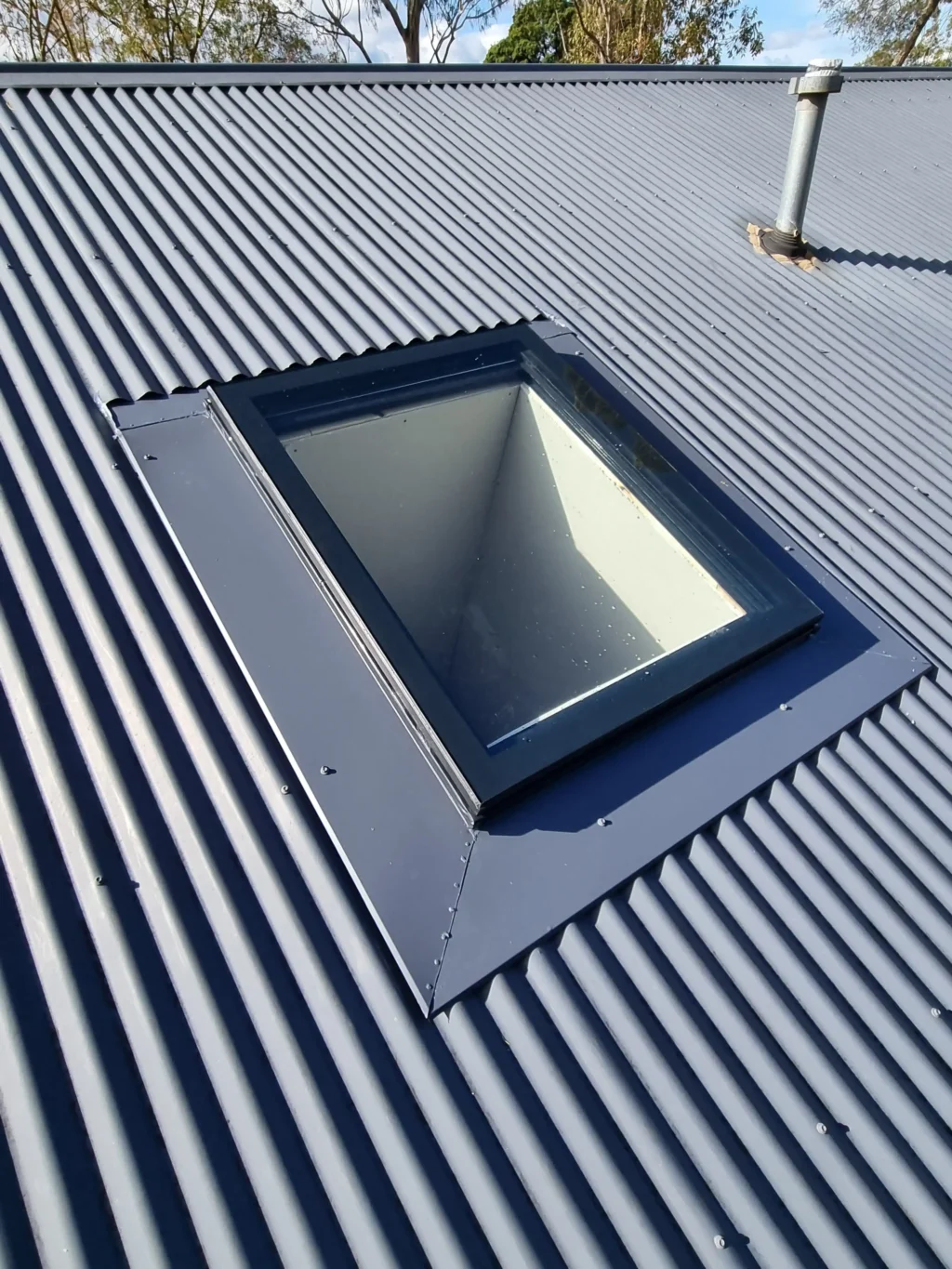 Square skylight on a pitched corrugated iron roof.
